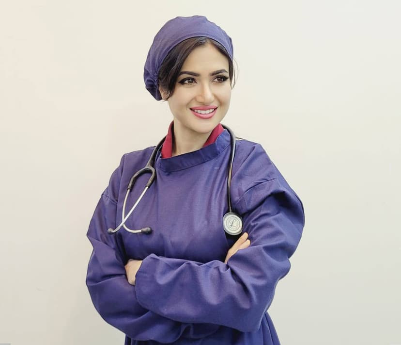 Dr. Nazia Iqbal in surgical gown performing hair transplant procedure